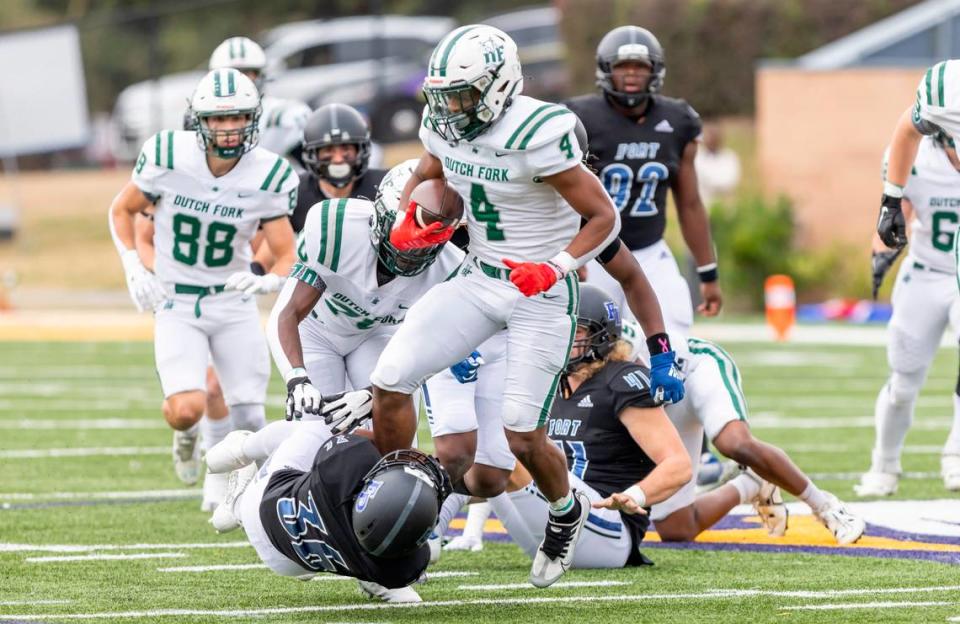 Jarvis Green (4) of Dutch Fork carries the ball as he gets wrapped up by Jalen White (36) of Fort Dorchester during the SCHSL Class 5A Football State Championship at Charles W.Johnson Stadium in Columbia, SC on Saturday, Dec. 3, 2022.