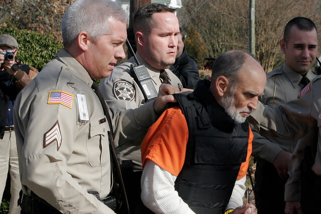 Gary Michael Hilton getting escorted to a police car.