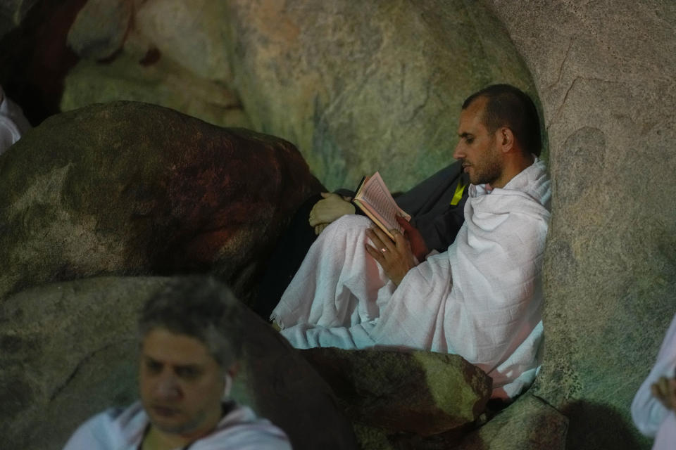 A pilgrim prays on the rocky hill known as the Mountain of Mercy, on the Plain of Arafat, during the annual Hajj pilgrimage, near the holy city of Mecca, Saudi Arabia, Tuesday, June 27, 2023. Around two million pilgrims are converging on Saudi Arabia's holy city of Mecca for the largest Hajj since the coronavirus pandemic severely curtailed access to one of Islam's five pillars. (AP Photo/Amr Nabil)