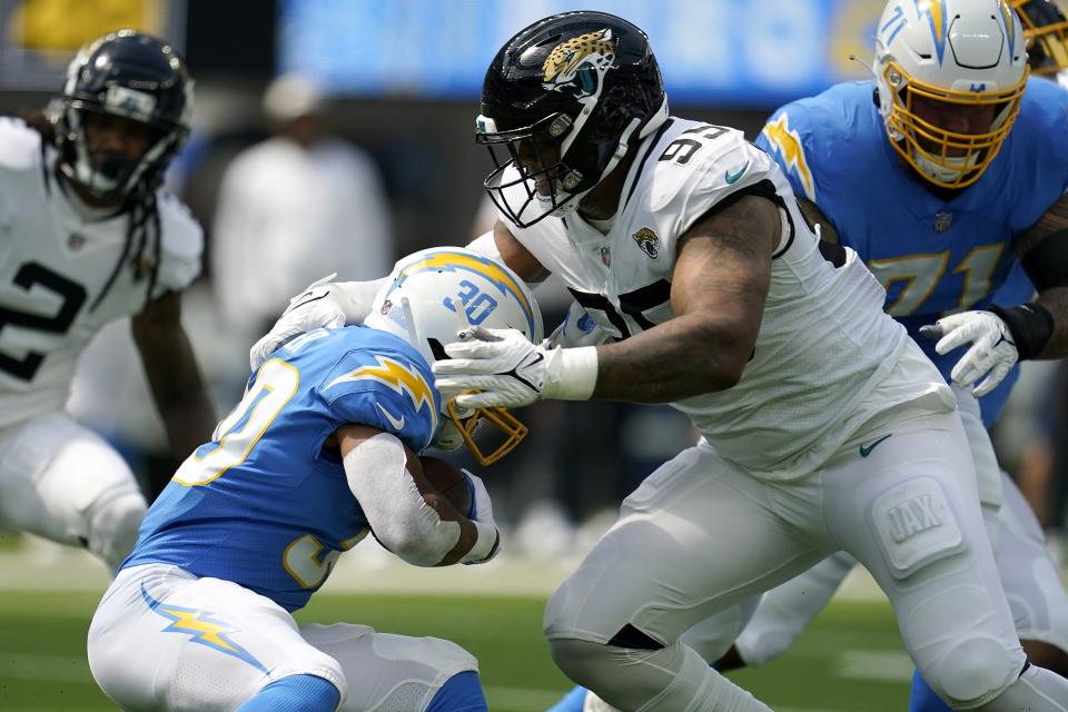 Los Angeles Chargers running back Austin Ekeler (30) is tackled by Jacksonville Jaguars defensive end Roy Robertson-Harris during the first half of an NFL football game in Inglewood, Calif., Sunday, Sept. 25, 2022. (AP Photo/Marcio Jose Sanchez)