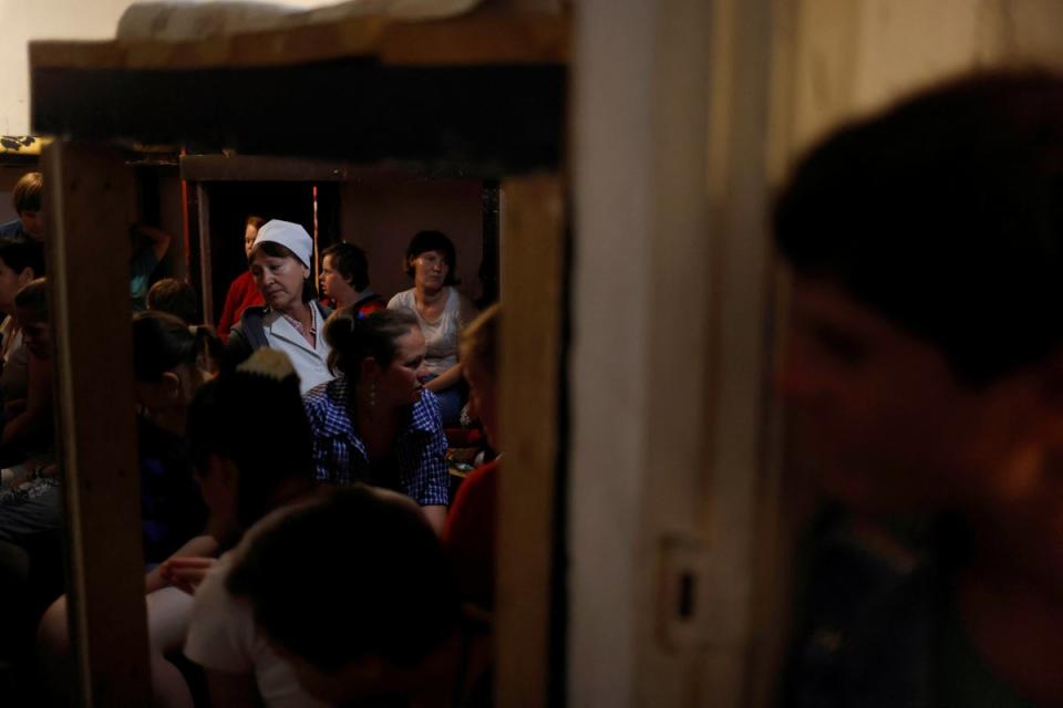 Nurse Ekaterina Masiuk, 57, comforts residents in a basement shelter at the orphanage (Reuters)