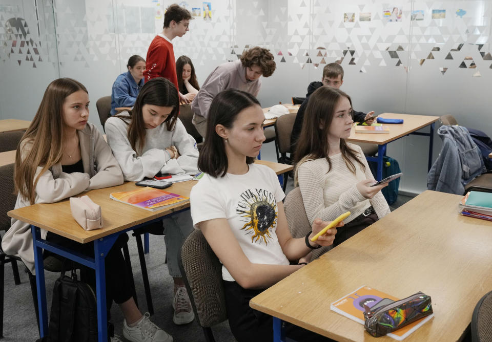 Students use their smartphones at a school run by the Unbreakable Ukraine foundation as they prepare for Ukraine's state final examinations, which are needed to enter university, in Warsaw, Poland, Wednesday June 7, 2023. Russian forces have destroyed 262 educational institutions and damaged another 3,019 in their invasion of Ukraine, according to government figures. For those who've fled to other countries, schooling is suffering in unprecedented ways, according to families, educators, experts and advocates. The effects of war and relocation combined with the challenges of studying in a new country are compounding educational setbacks for young refugees. (AP Photo/Czarek Sokolowski)