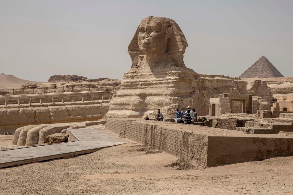 People work at the site of the Sphinx and the Giza Pyramids, in Giza, Egypt, Wednesday, March 25, 2020.