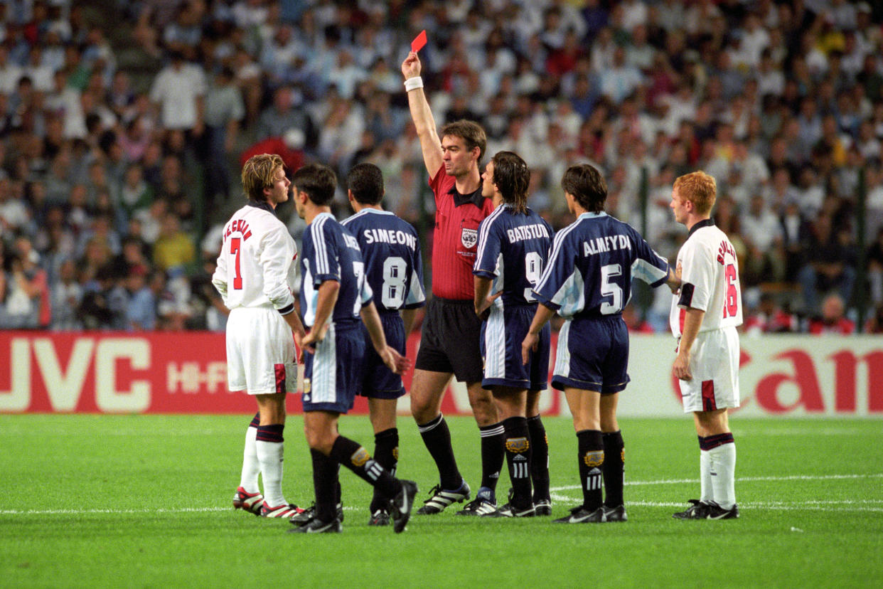 England's David Beckham (L) is given the red card by Danish referee Kim Milton Nielsen, after a foul on Argentina's Diego Simeone during their France '98 World Cup second round match held in St Etienne. argentina won the match 4-3 on penalties (2-2 after extra time).   (Photo by Adam Butler - PA Images/PA Images via Getty Images)