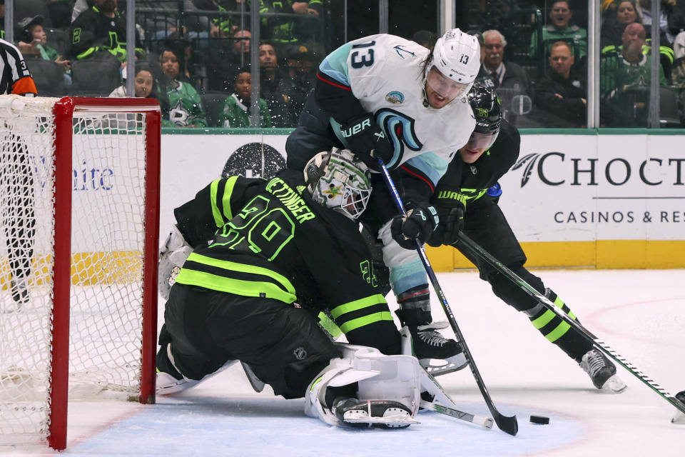 Dallas Stars goaltender Jake Oettinger (29) defends a shot by Seattle Kraken left wing Brandon Tanev (13) in the second period during an NHL hockey game on Saturday, April 13, 2024, in Dallas. (AP Photo/Richard W. Rodriguez)