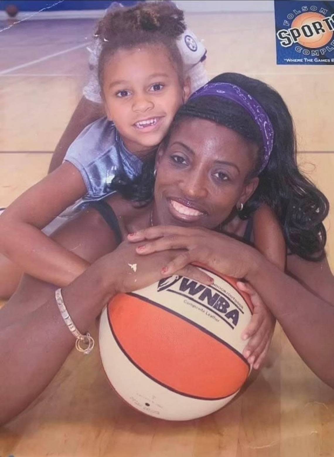 Three-year-old McKenzie Forbes hugs Sacramento Monarchs legend Ruthie Bolton.