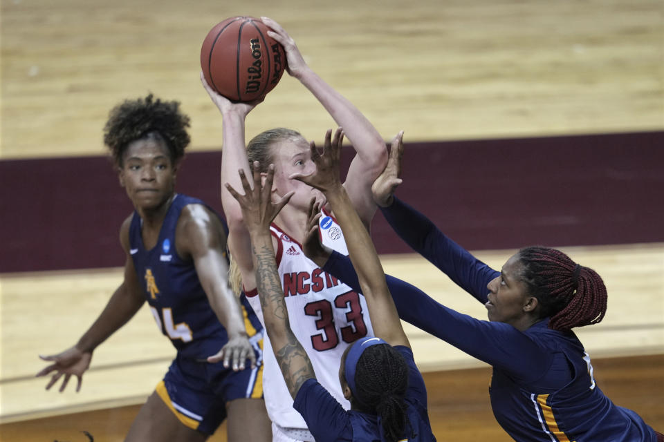 North Carolina State's Elissa Cunane (33) tries to shoot against North Carolina A&T players during the first half of a college basketball game in the first round of the women's NCAA tournament at the University Events Center in San Marcos, Texas, Sunday, March 21, 2021. (AP Photo/Chuck Burton)