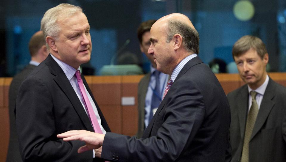 European Commissioner for the Economy Olli Rehn, left, speaks with Spanish Economy Minister Luis de Guindos, second right, during a meeting of the eurogroup at the EU Council building in Brussels on Monday, Feb. 17, 2014. Europe's economy is growing faster, raising hopes for a sustainable recovery, but that may not be enough to bring sky-high levels of unemployment down anytime soon. (AP Photo/Virginia Mayo)