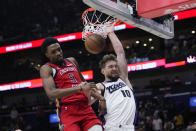 Sacramento Kings forward Domantas Sabonis (10) slam dunks against New Orleans Pelicans forward Herbert Jones (5) in the first half of an NBA basketball play-in tournament game in New Orleans, Friday, April 19, 2024. (AP Photo/Gerald Herbert)