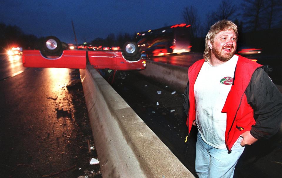 Donald Busch Jr. talks to a highway worker after a tornado picked up his truck on I-71 in Blue Ash and tossed it around. Just across the highway from this scene, a man was thrown from a car and killed.