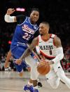 Portland Trail Blazers guard Damian Lillard, right, drives past Sacramento Kings center Richaun Holmes during the first half of an NBA basketball game in Portland, Ore., Saturday, March 7, 2020. (AP Photo/Steve Dipaola)