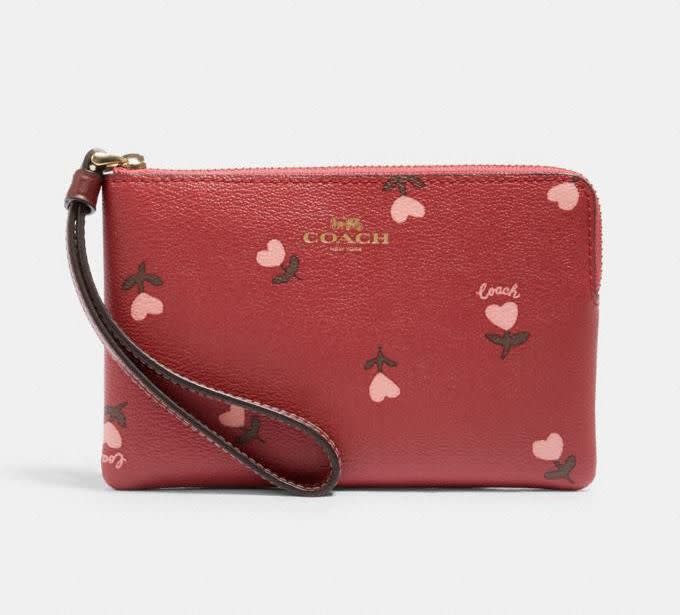 Bolso de muñeca con cremallera y estampado floral con corazones (imagen a través de Coach Outlet).