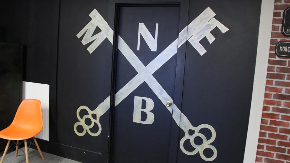 The logo for Mass Escape painted across a door in the lobby at Mass Escape in New Bedford.