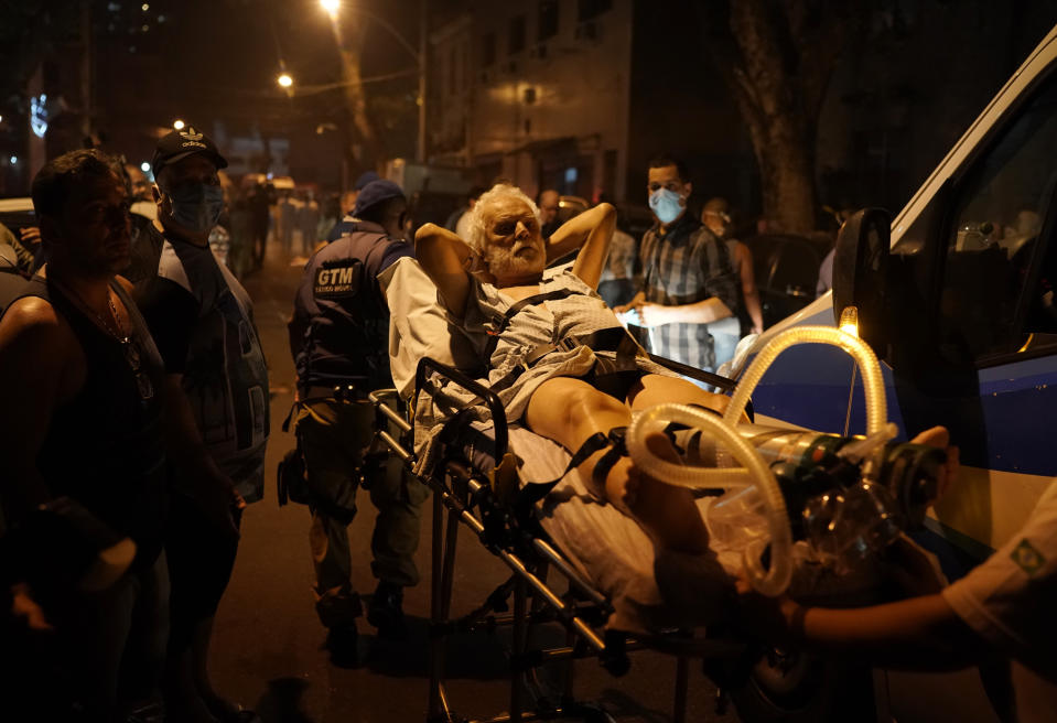 Patients are evacuated from a burning hospital in Rio de Janeiro, Brazil, Thursday, Sept. 12, 2019. The fire forced staff to hastily evacuate patients and temporarily settle some on sheets and mattresses in the street while firefighters fought the blaze. (AP Photo/Leo Correa)