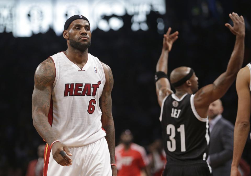 Miami Heat's LeBron James (6) walks toward the bench during a timeout in the first half of an NBA basketball game as Brooklyn Nets' Jason Terry (31) gestures to the crowd on Friday, Jan. 10, 2014, in New York. (AP Photo/Frank Franklin II)