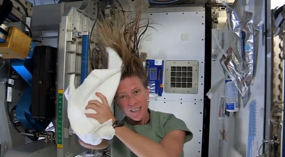 To wash her hair in space, astronaut Karen Nyberg uses a towel first to help add no-rinse shampoo to her hair, then to dry her hair in this still from a video recorded on the International Space Station and posted online on July 9, 2013. Reusin