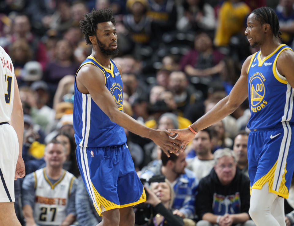 Golden State Warriors forward Jonathan Kuminga, right, congratulates forward Andrew Wiggins after his basket in the first half of an NBA basketball game against the Denver Nuggets, Thursday, Feb. 2, 2023, in Denver. (AP Photo/David Zalubowski)