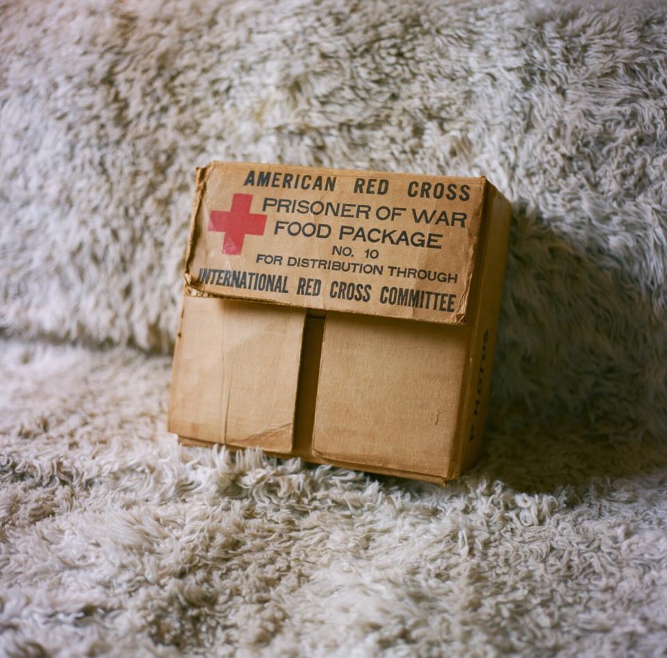 Andrzej's box inscribed, "American Red Cross Prisoner of War Food Package," sits on the couch in his living room.