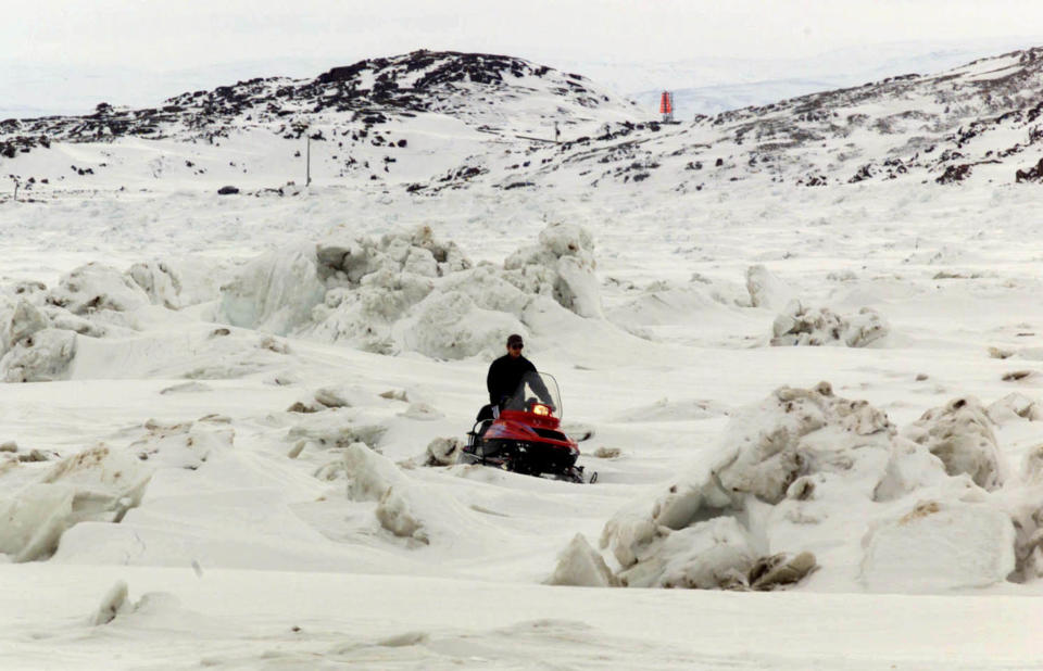 A snowmobiler makes his way over the ice on Frobisher Bay in the arctic town of Iqaluit, March 29. Nunavut, which has a population of 25,000 and covers over two million square kilometers of arctic terrain, will become a new Canadian territory April 1. SB/MR/WS