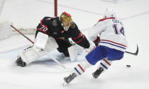 Montreal Canadiens center Nick Suzuki, right, fails to put the puck past Ottawa Senators goaltender Joonas Korpisalo, left, during overtime NHL hockey game action in Ottawa, Ontario, Saturday, April 13, 2024. (Adrian Wyld/The Canadian Press via AP)