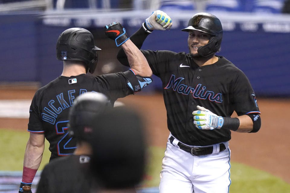 Miami Marlins' Miguel Rojas, right, is met by Corey Dickerson after hitting a solo home run during the first inning of a baseball game against the Milwaukee Brewers, Saturday, May 8, 2021, in Miami. (AP Photo/Lynne Sladky)
