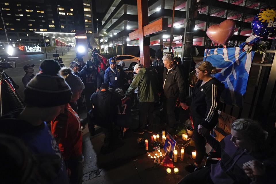 Attendees holds hands and pray during a prayer vigil for Buffalo Bills' Damar Hamlin outside of the University of Cincinnati Medical Center, Tuesday, Jan. 3, 2023, in Cincinnati. Hamlin was taken to the hospital after collapsing on the field during an NFL football game against the Cincinnati Bengals on Monday night.(AP Photo/Darron Cummings)