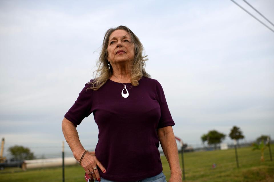 Cynthia Benson fights back tears while looking out at petrochemical barges on the San Jacinto River.