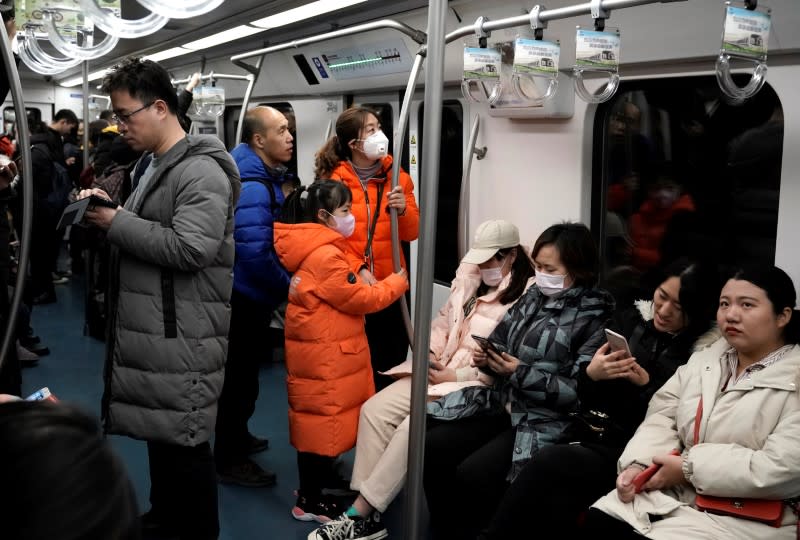 People wearing masks are pictured on the subway in Beijing