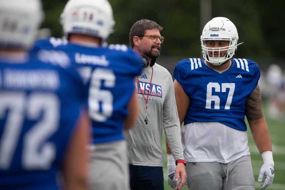 Kansas football offensive lineman Dominick Puni (67) talks with offensive line coach Scott Fuchs during a 2023 practice.