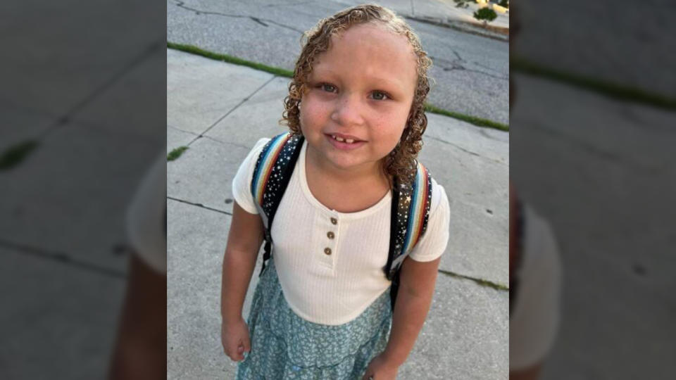 Jurnee Hoffmeyer stands on a sidewalk, looking up at the camera.