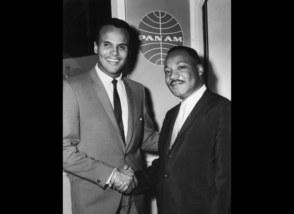 American singer and actor Harry Belafonte Jr. (left) shakes hands with American civil rights leader Rev. Martin Luther King Jr. (1929 - 1968) at Kennedy International Airport on Aug. 14, 1964 before he and his family board a Pan American jet bound for Conakry, Guinea, New York City. Belafonte was invited to Conakry by Guinea's president, Sekou Toure, to dedicate a theater and cultural center.  (Hulton Archive / Getty Images)