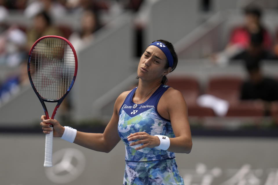 Caroline Garcia of France reacts after losing a point to Iga Swiatek of Poland during the women's singles quarterfinal match in the China Open tennis tournament at the Diamond Court in Beijing, Friday, Oct. 6, 2023. (AP Photo/Andy Wong)