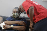 Samuel Nunez, left, receives well-wishes from a neighbor after a funeral service for his daughter Lydia Nunez, who died from COVID-19, Tuesday, July 21, 2020, in Los Angeles. (AP Photo/Marcio Jose Sanchez)