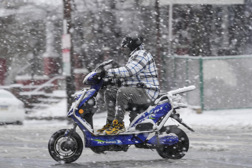 A person drives a scooter during a winter snow storm in Philadelphia, Tuesday, Feb. 13, 2024. Parts of the Northeast were hit Tuesday by a snowstorm that canceled flights and schools and prompted warnings for people to stay off the roads, while some areas that anticipated heavy snow were getting less than that as the weather pattern changed. (AP Photo/Matt Rourke)