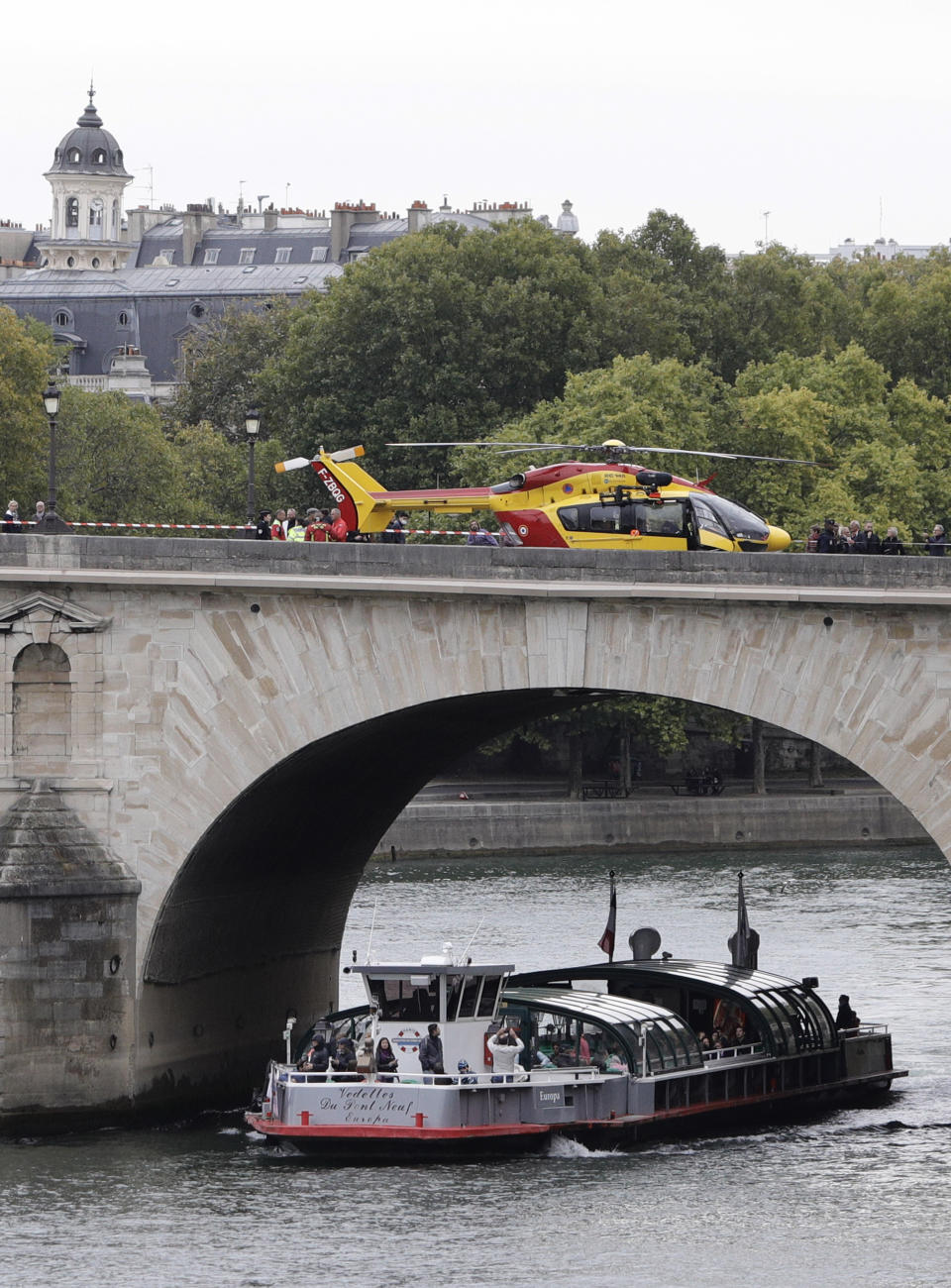 A helicopter is parked on the Pont Marie bridge after an incident at the police headquarters in Paris, Thursday, Oct. 3, 2019. A French police union official says an attacker armed with a knife has killed one officer inside Paris police headquarters before he was shot and killed. (AP Photo/Kamil Zihnioglu)