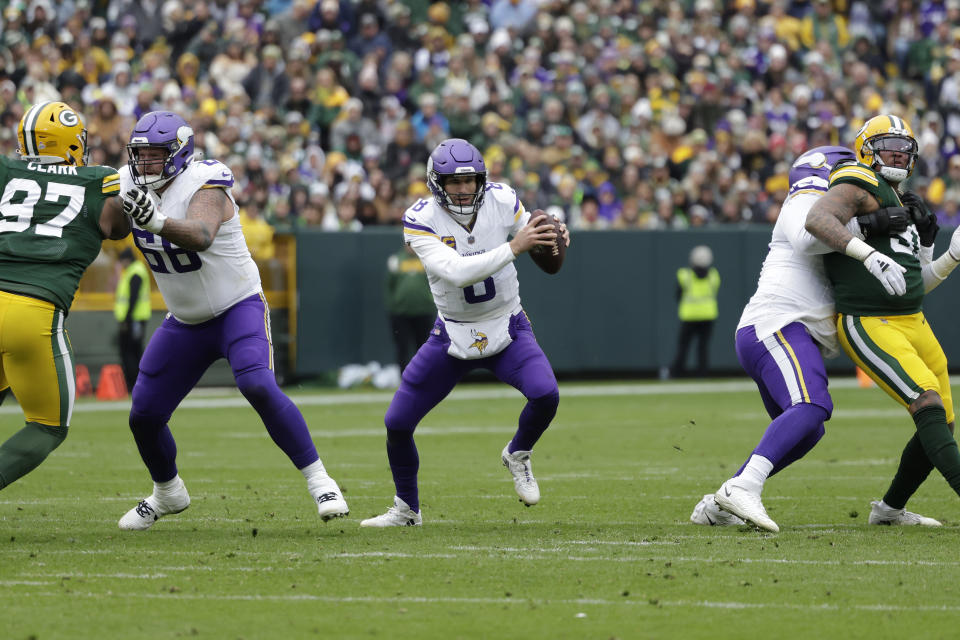 Minnesota Vikings quarterback Kirk Cousins (8) handles the football during the second half of an NFL football game against the Green Bay Packers, Sunday, Oct. 29, 2023, in Green Bay, Wis. Cousins was injured during the play. (AP Photo/Matt Ludtke)