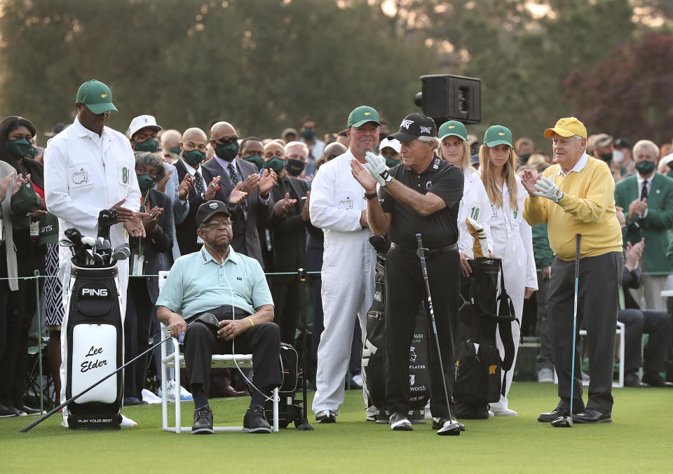 Honorary starter Lee Elder, seated at left, is applauded by three-time Masters champion Gary Player, and six-time Masters champion Jack Nicklaus, right, as he is introduced during the ceremonial tee shots to begin the Masters golf tournament at Augusta National Golf Club in Augusta, Ga., Thursday, April 8, 2021. (Curtis Compton/Atlanta Journal-Constitution via AP)