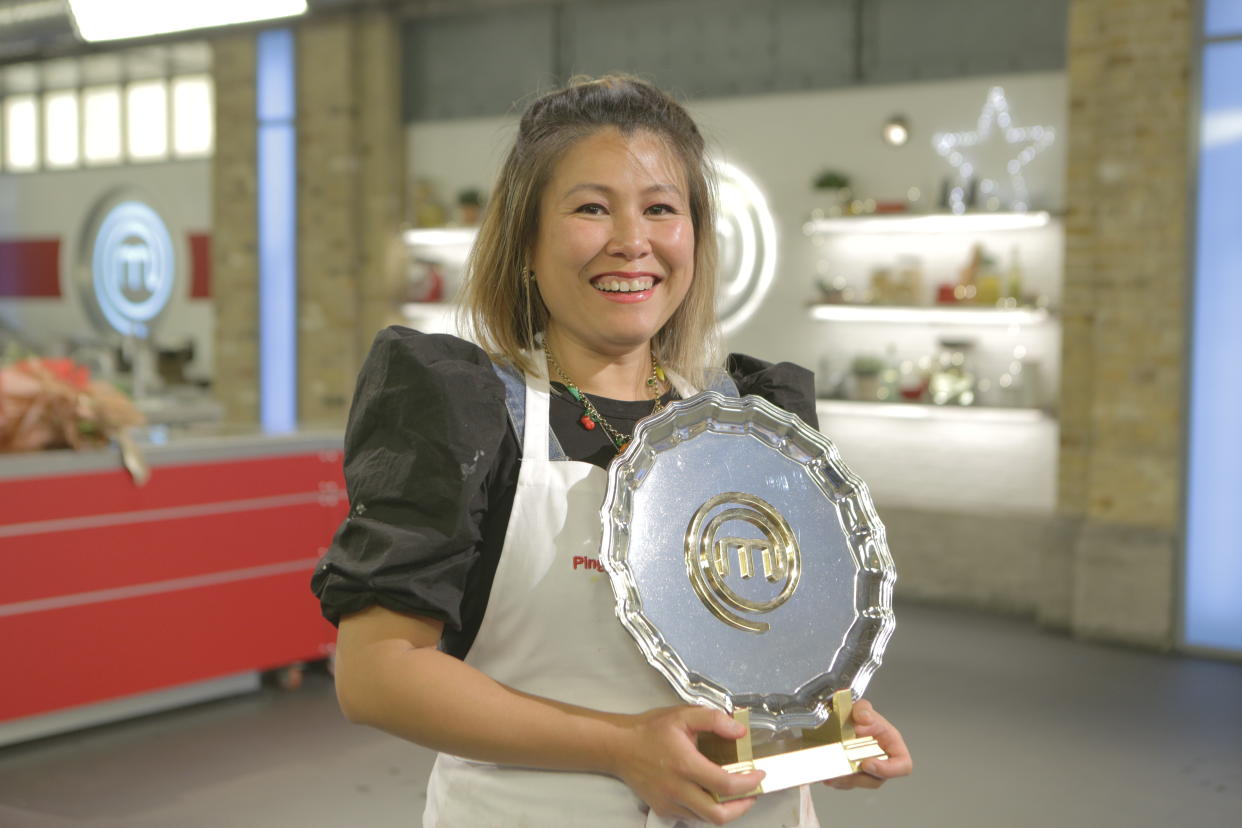 Ping Coombes holding the MasterChef plate and smiling.