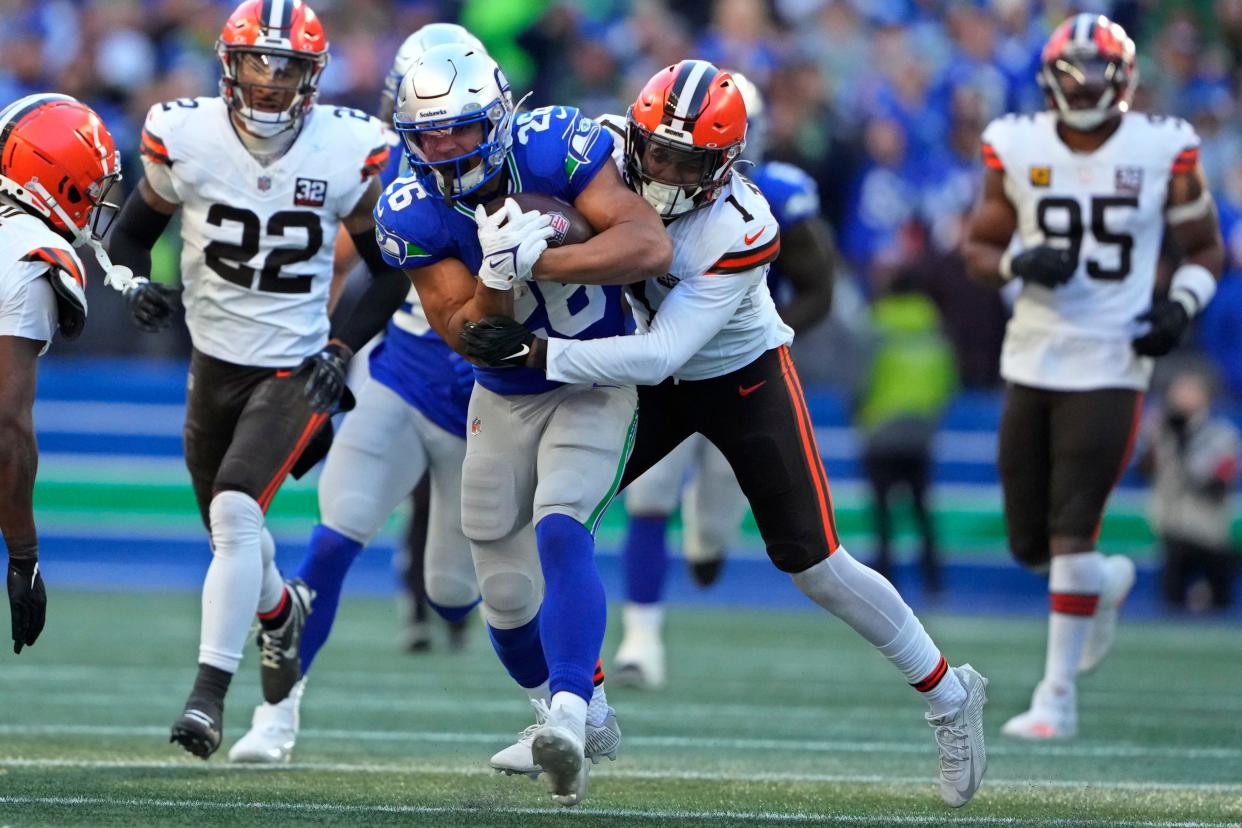 Seattle Seahawks running back Zach Charbonnet (26) is tackled by Cleveland Browns safety Juan Thornhill (1) on Oct. 29, 2023, in Seattle.