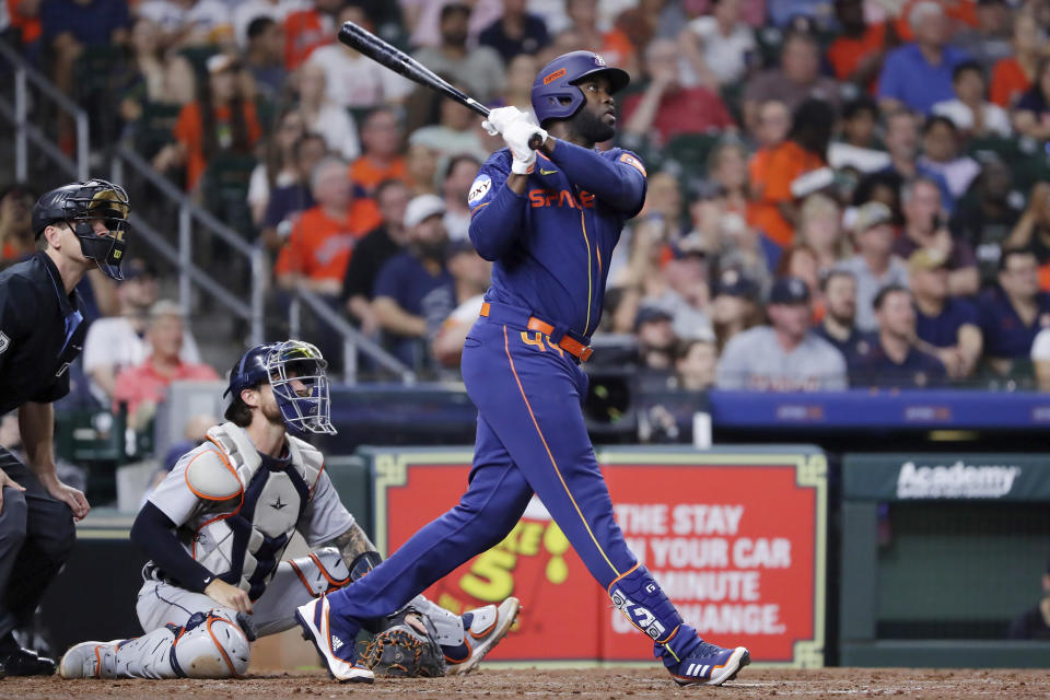 Houston Astros batter Yordan Alvarez, right, watches his three-run home run in front of Detroit Tigers catcher Eric Haase, center, and umpire Ben May, left, during the fifth inning of a baseball game Monday, April 3, 2023, in Houston. It was Alvarez's 100th career home run. (AP Photo/Michael Wyke)