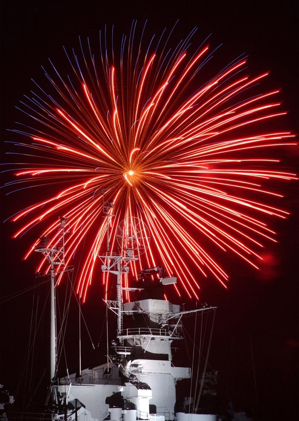 In this file photo, a fireworks burst explodes over the  Battleship Massachusetts radar tower at Battleship Cove in Fall River.