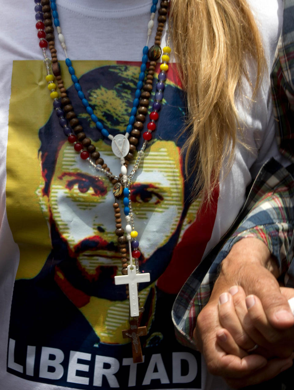 Lilian Tintori wife of jailed opposition leader Leopoldo Lopez wears a t-shirt with an image of him and a sign that reads in Spanish "freedom" during an anti-government protest in Caracas, Venezuela, Saturday, April 26, 2014. Student organizers at the last minute decided against marching downtown to avoid a confrontation with security forces in the government-controlled district. Instead they concentrated in the wealthier, eastern neighborhoods that have been the hotbed of unrest since February. (AP Photo/Fernando Llano)