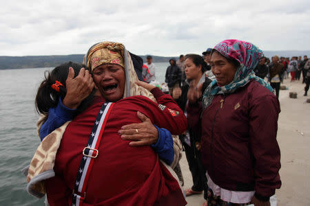 Relatives cry while waiting for news on missing family members who were on a ferry that sank yesterday in Lake Toba, at Tigaras Port, Simalungun, North Sumatra, Indonesia June 19, 2018. REUTERS/Albert Damanik