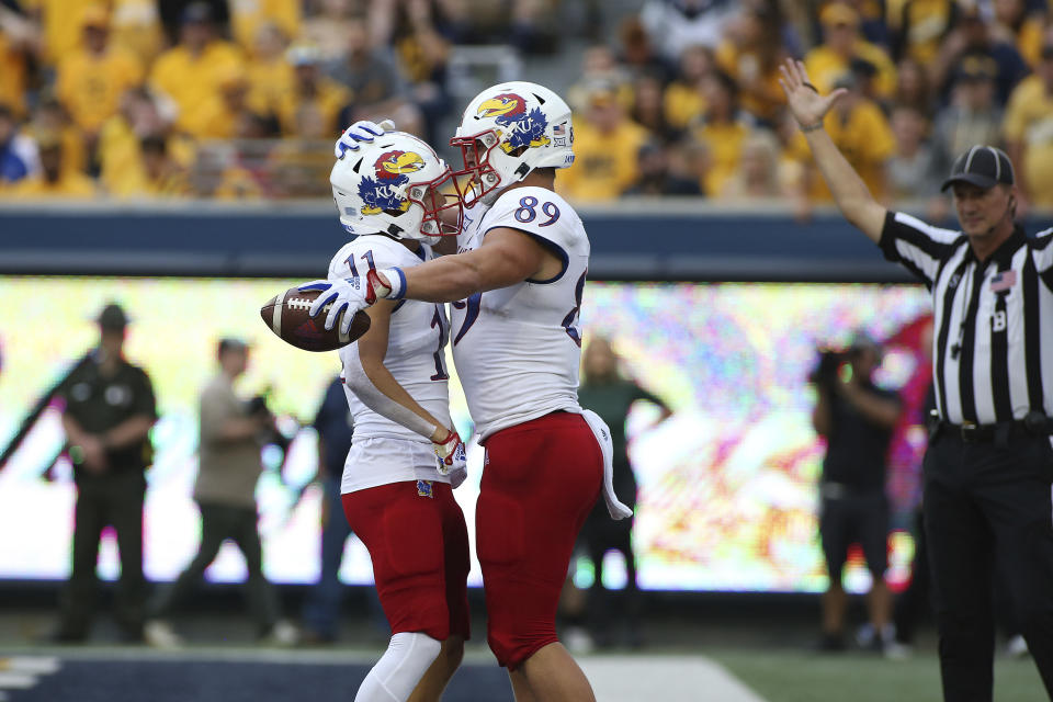 Kansas wide receiver Luke Grimm (11) and tight end Mason Fairchild (89) celebrate after a touchdown score against West Virginia during the first half of an NCAA college football game in Morgantown, W.Va., Saturday, Sept. 10, 2022. (AP Photo/Kathleen Batten)