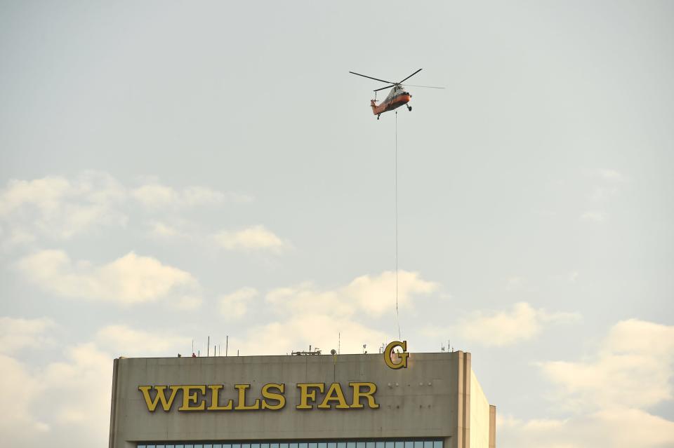 Crews from Southeastern Lighting Solutions with the help of a 1958 vintage Sikorsky S-58 helicopter removed the giant letters of the Wells Fargo signage on the Wells Fargo Center in downtown Jacksonville, Fla. and gently lowered them onto a pier in the shipyards area.
