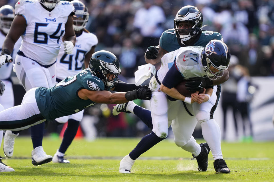 Philadelphia Eagles' T.J. Edwards, left, and Philadelphia Eagles' Javon Hargrave try and stop Tennessee Titans' Ryan Tannehill during the first half of an NFL football game, Sunday, Dec. 4, 2022, in Philadelphia. (AP Photo/Matt Rourke)