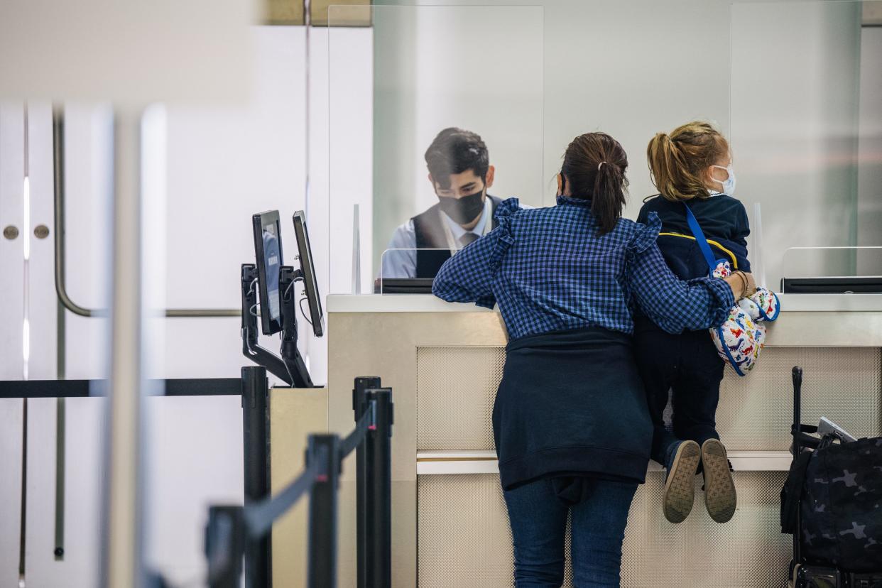 A woman and her child speak with an airline attendant at Houston's George Bush Intercontinental Airport on Jan. 6, 2022 as thousands of U.S. flights were canceled again. (Photo by Brandon Bell/Getty Images)