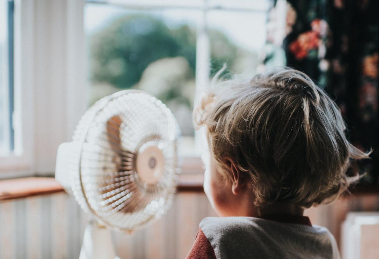 The temperature you feel on a hot, sunny day doesn't always match the thermostat. <a href="https://www.gettyimages.com/detail/photo/little-boy-looking-at-a-fan-royalty-free-image/1157634115" rel="nofollow noopener" target="_blank" data-ylk="slk:Catherine Falls Commercial/Moment via Getty Images;elm:context_link;itc:0;sec:content-canvas" class="link ">Catherine Falls Commercial/Moment via Getty Images</a>