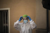 In this July 31, 2020 file photo, Dr. Marta Ruberte prepares to visit an elderly patient at home in Sant Sadurní d'Anoia, Catalonia region, Spain. In contrast to the darkest weeks of March and April, when the virus ripped through Spain's elderly in nursing homes and pushed the country's hospitals to the breaking point, the pressure is now on Spain's neighborhood health clinics. (AP Photo/Felipe Dana)