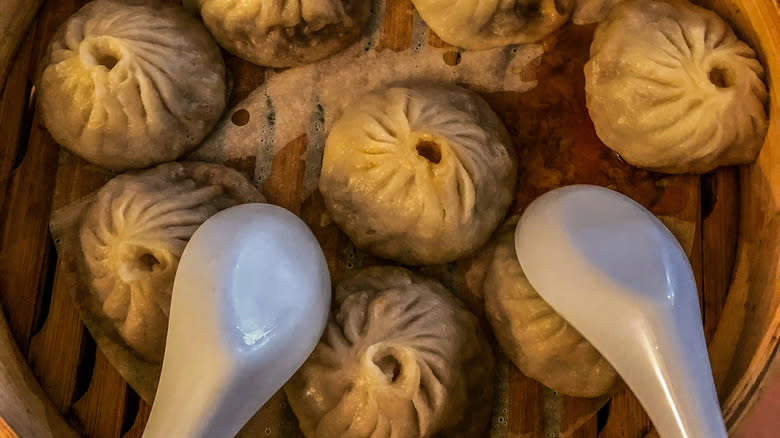 soup dumplings with spoons